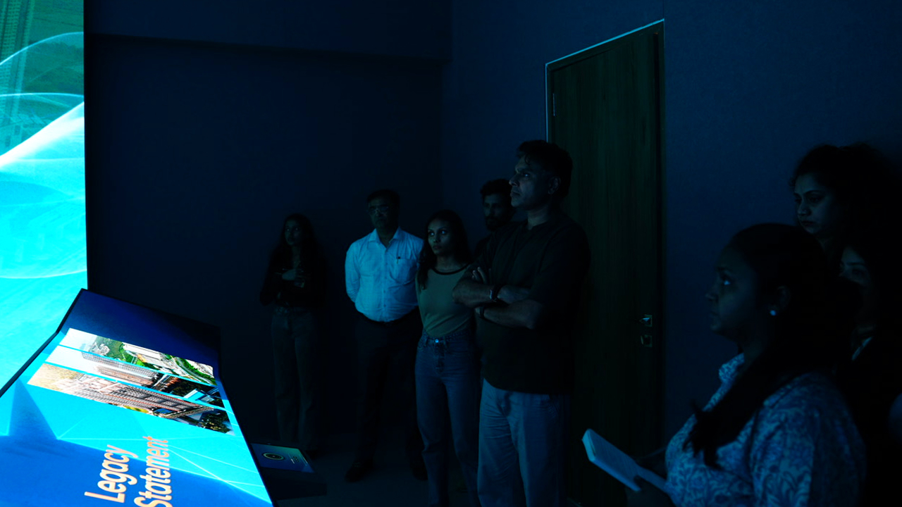 Visitors experiencing Ajmera Manhattan’s synchronized immersive digital presentation